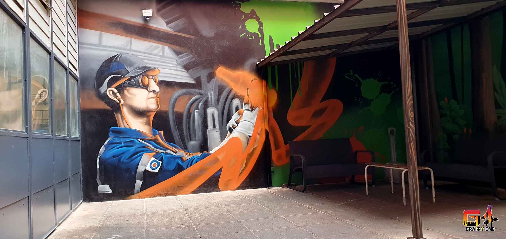 Fresque murale sur l'art du verre peinte par Graffit One dans la salle de pose de l'entreprise O-I à Béziers